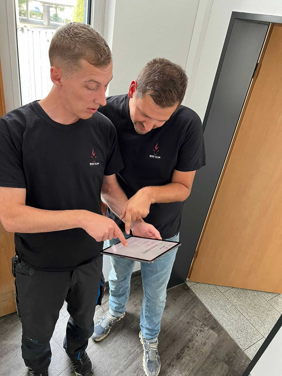 BSD Ulm Brandschutz Dienstleistungen -  Zwei Mitarbeiter prüfen Checkliste auf Klemmbrett